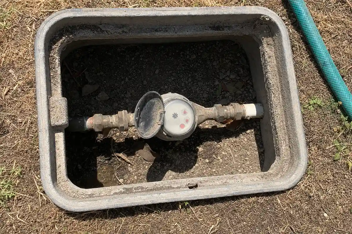 Water meter box with the lid off and the leak indicator dial showing