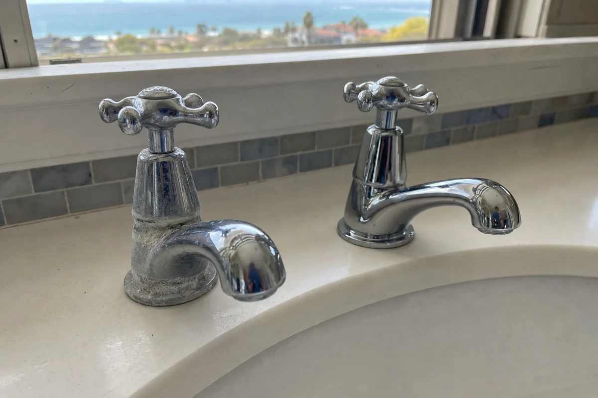 Faucet with mineral crust beside a clean faucet with none